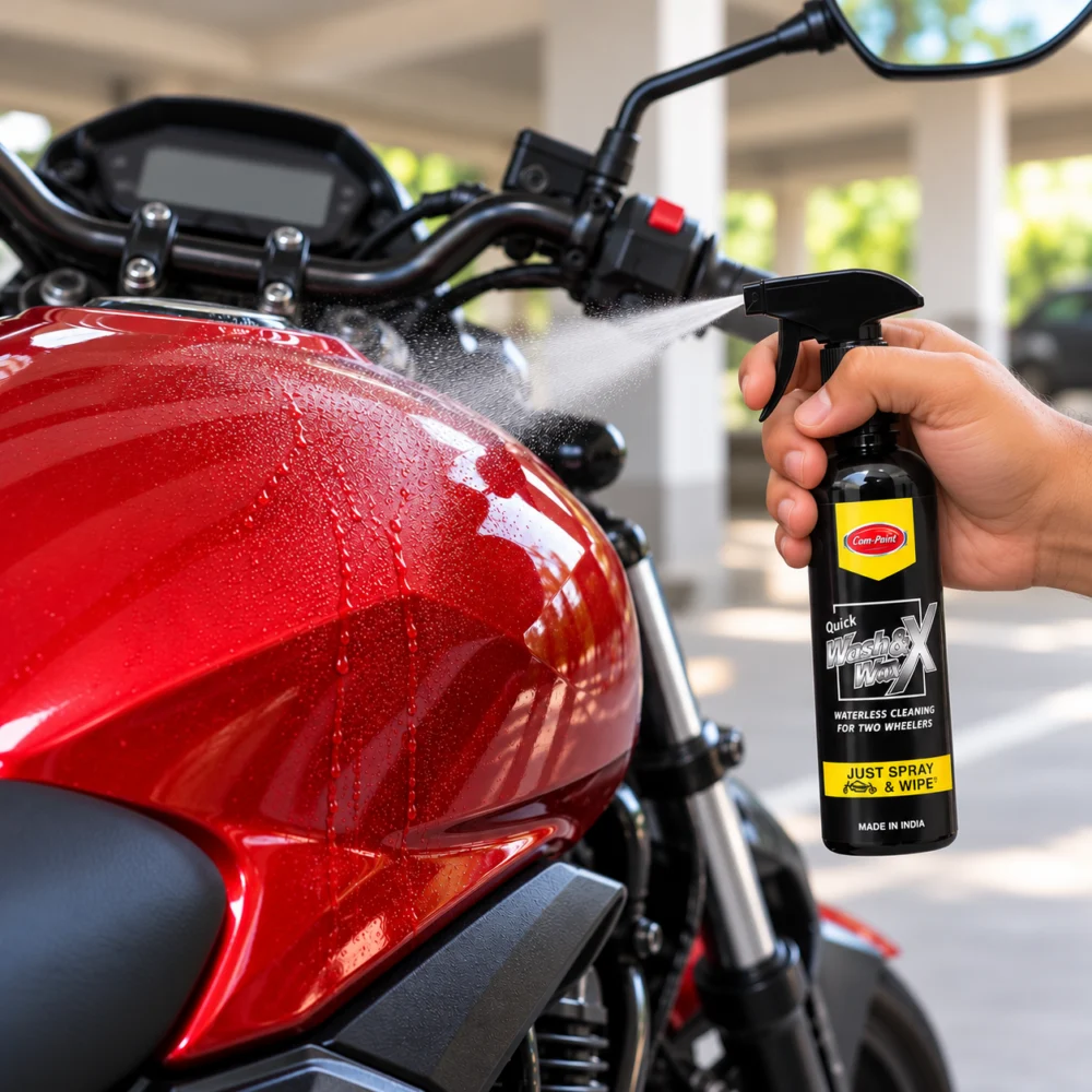 Spraying Com-Paint Wash & Wax 200 ml on a dusty red motorcycle fuel tank